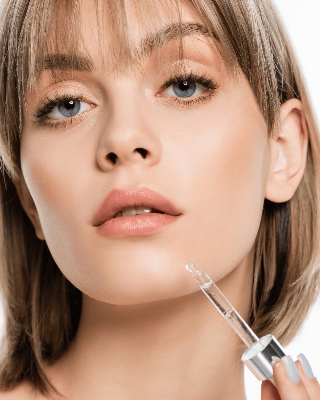 Chica con una pipeta de un serum.